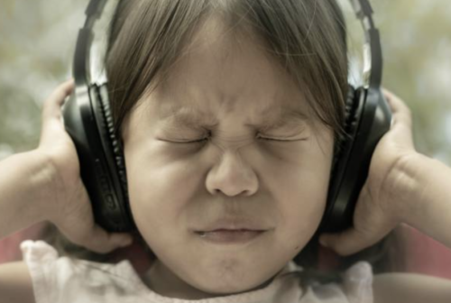 child wearing headphones and schrunching her face - toxic stress